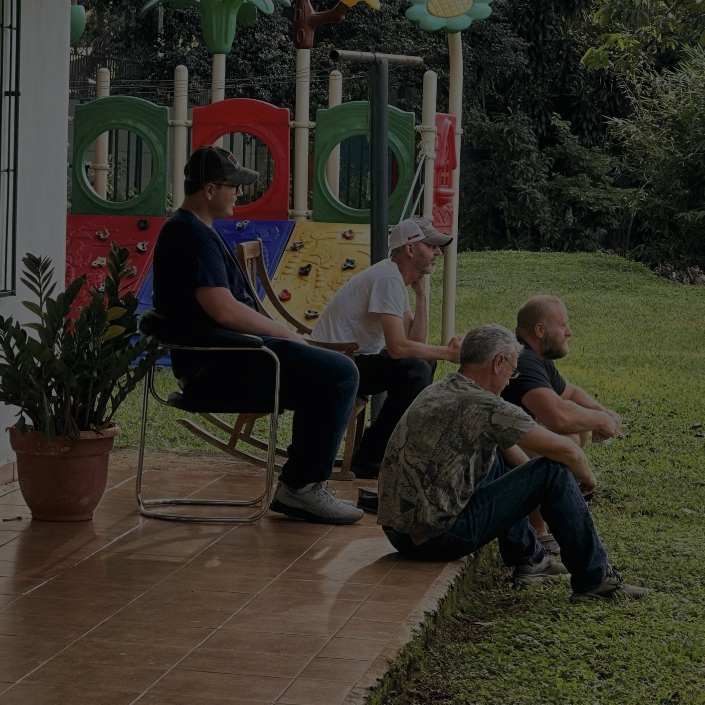 a group of men sitting on a patio